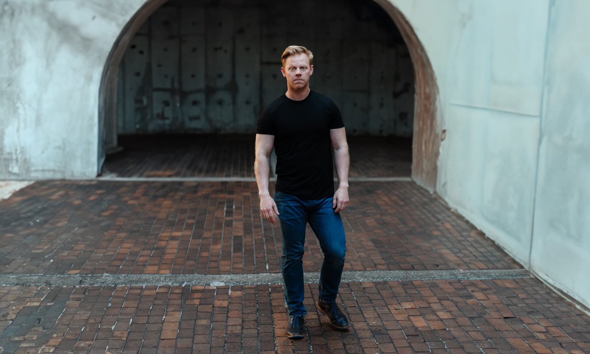 Kenneth Stavert standing in front of an arched doorway